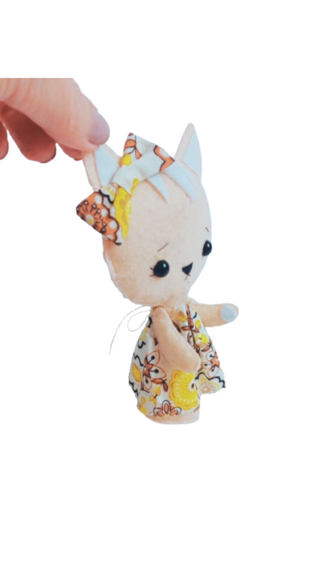 Close-up of embroidered face on felt cat plush doll