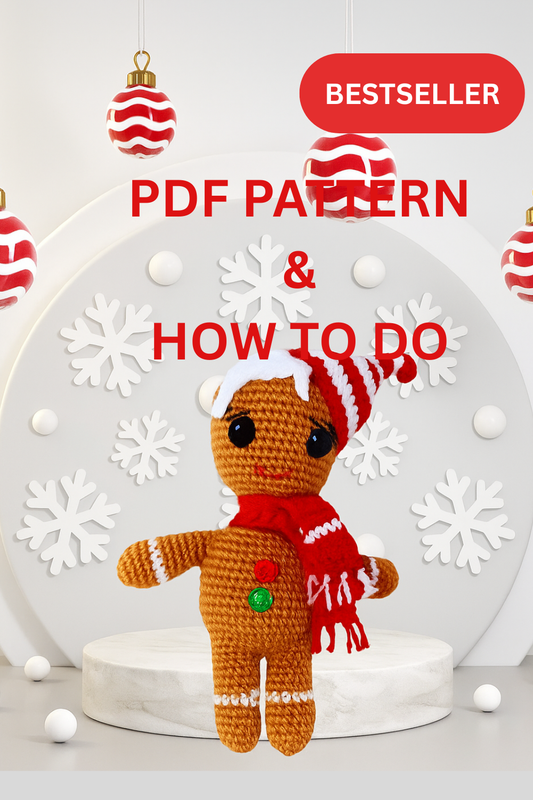 Crocheted gingerbread man toy with a red scarf and white hat on a white background with snowflakes and Christmas ornaments.