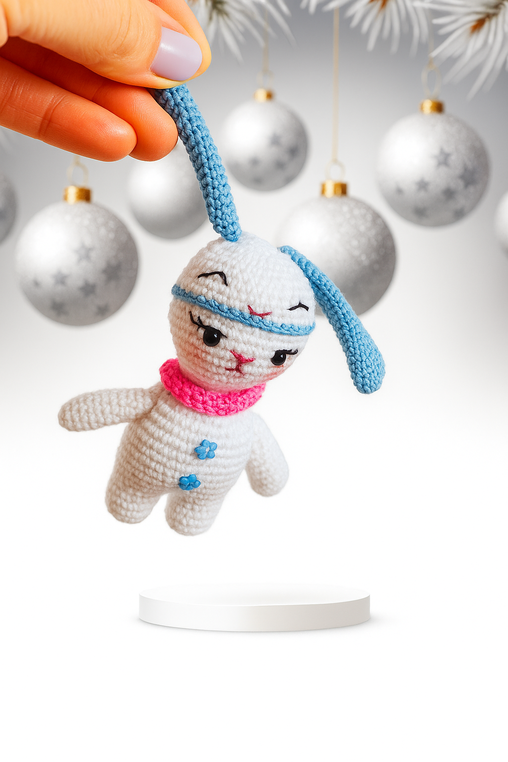 Hand holding a small crocheted white bunny ornament